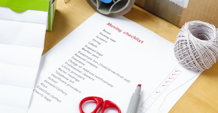 A moving checklist beside packed boxes