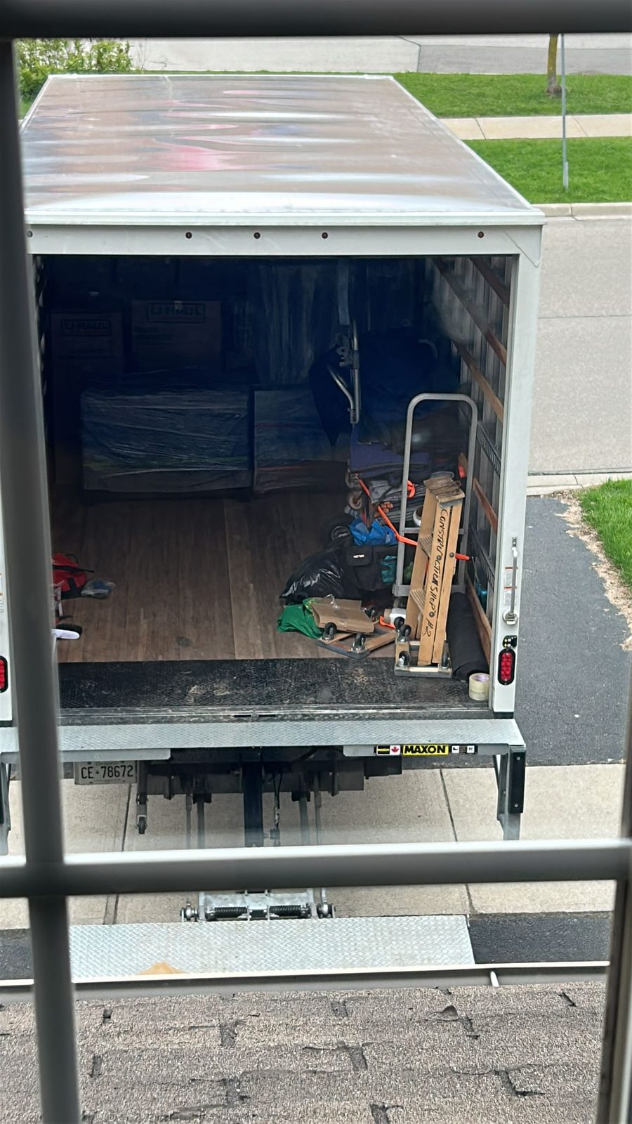 The open rear of a loaded Homeboy Movers box truck with a dolly, packed and ready to go
