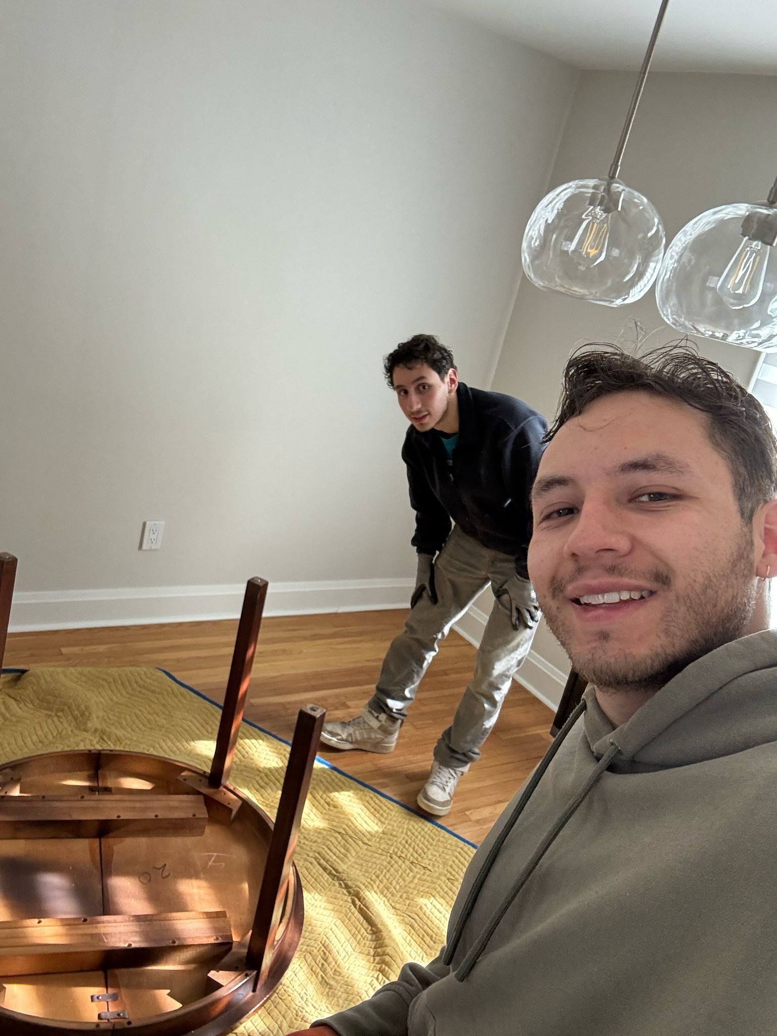 Homeboy Movers crew carefully wrapping a dining table for a residential move